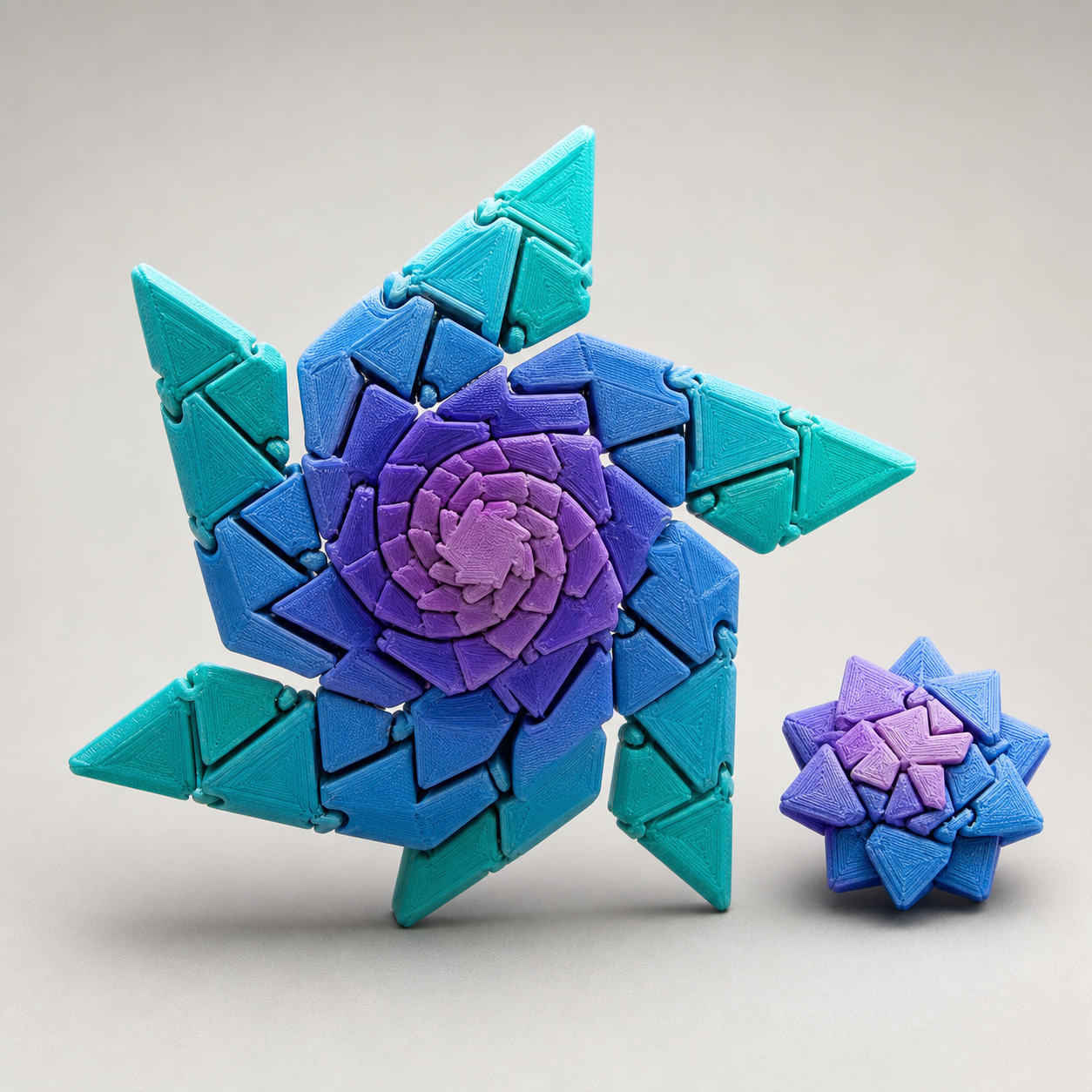 Unbranded teal blue and violet 3D-printed expanding fidget star shown open beside a compact closed star