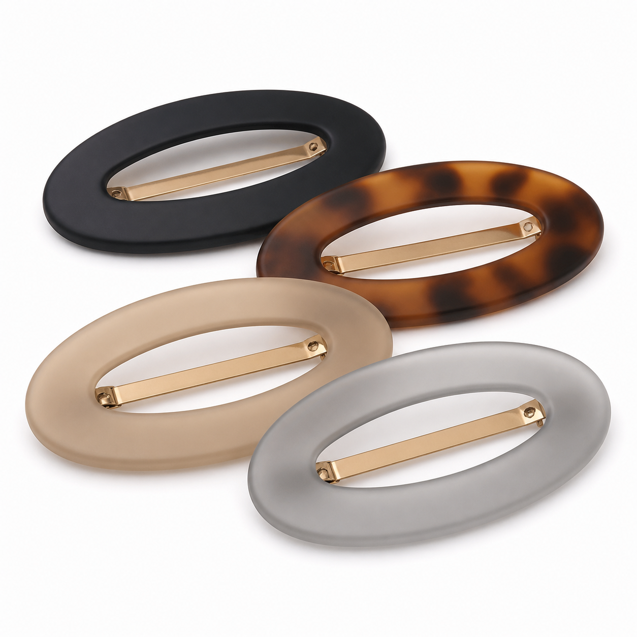 Four low-profile oval hair clips in black tortoiseshell beige and translucent gray