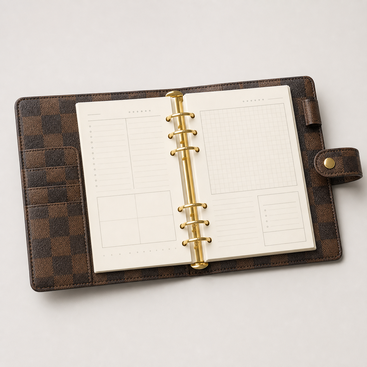 Unbranded brown checkered refillable A5 six-ring planner binder open to cream daily planning and grid pages with card pockets and snap closure